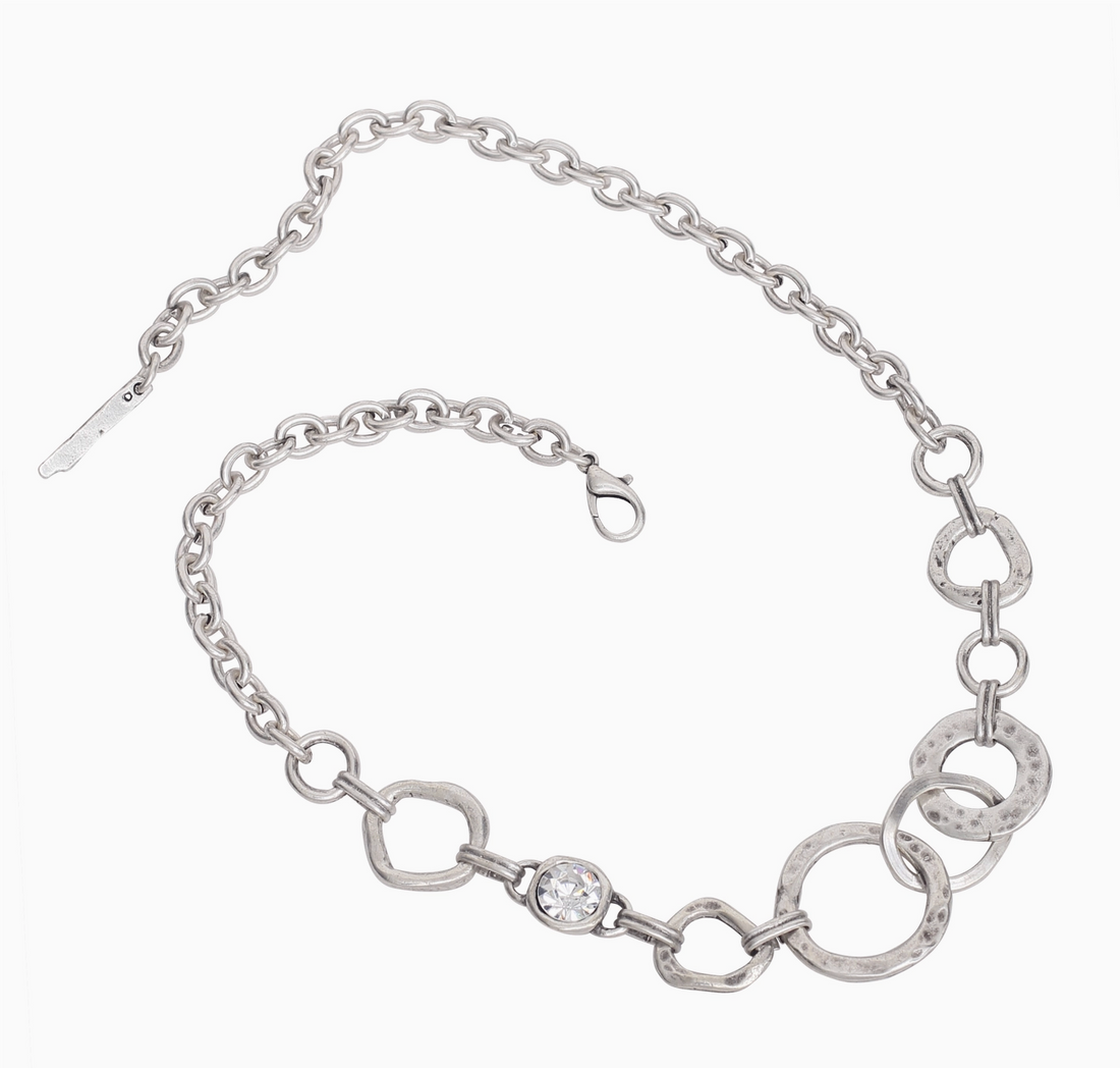 A bohemian-style silver circle statement necklace by Suki’s Wardrobe, showing the scale of the sculptural linked circle links and lobster clasp.