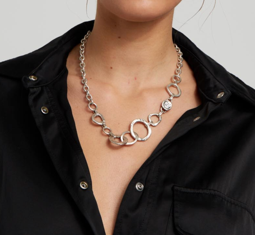 Close-up detail shown on a model of the artisan sculptural texture and length of the Suki’s Wardrobe silver boho circle necklace.
