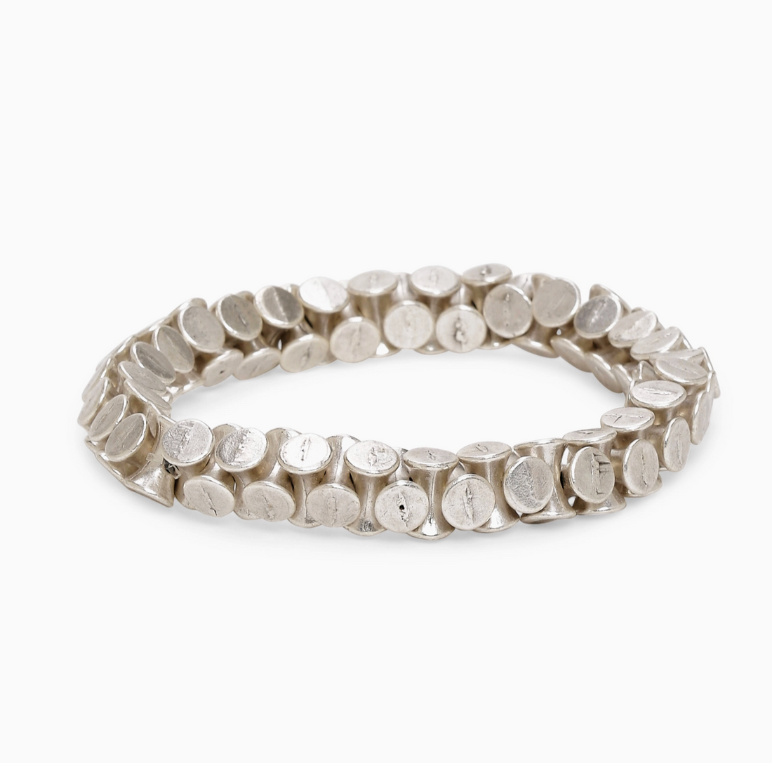 Minimalist liquid-metal aesthetic of the Elara silver ribbon cuff from Suki’s Wardrobe.