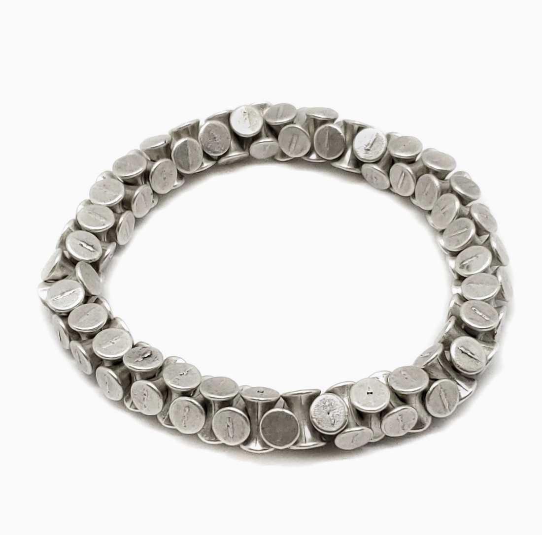 Zoomed out liquid-metal aesthetic of the Elara silver ribbon cuff from Suki’s Wardrobe.